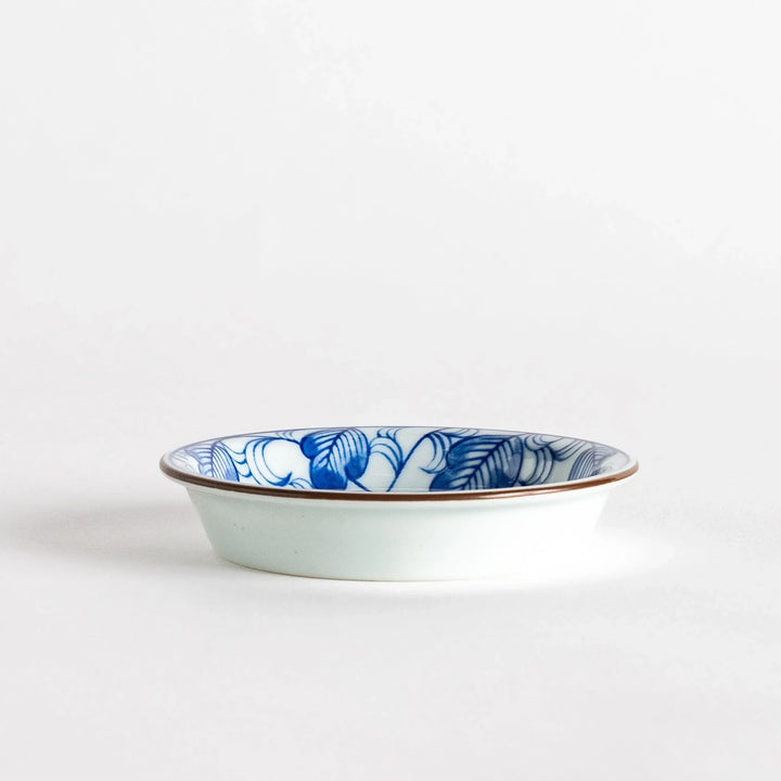 A round saucer featuring a delicate blue floral design on a white background.