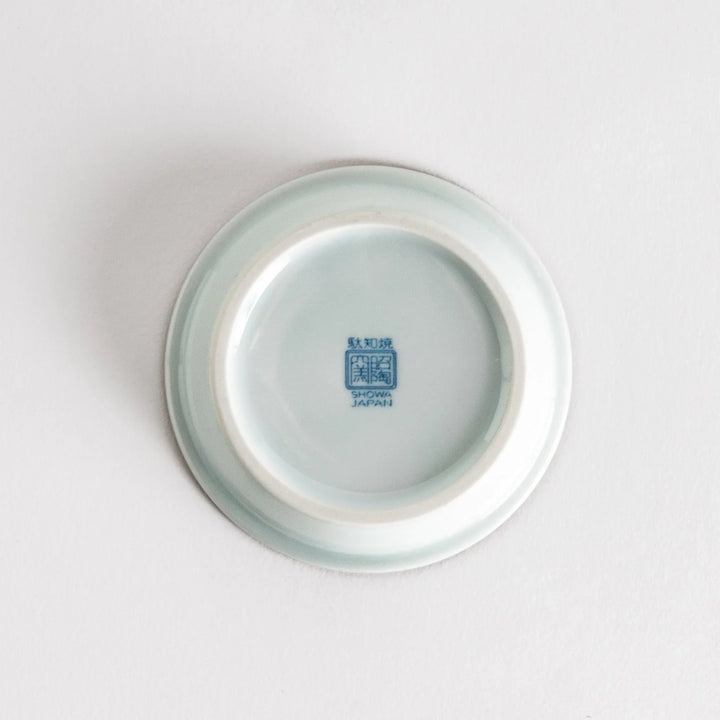 A round saucer featuring a delicate blue floral design on a white background.