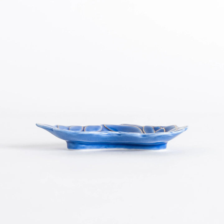 Side view of the blue mini sauce dish with a gold chrysanthemum design. The dish has a shallow, curved shape.