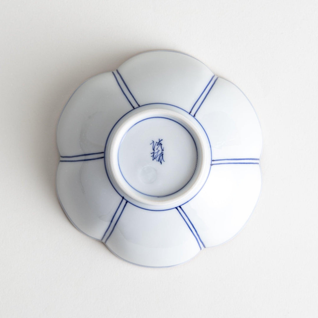 A white ceramic bowl with a floral shape, featuring delicate blue lines and an orange rim.