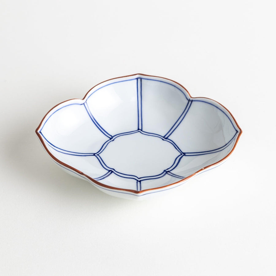A ceramic bowl shaped like a quince with blue line detailing.