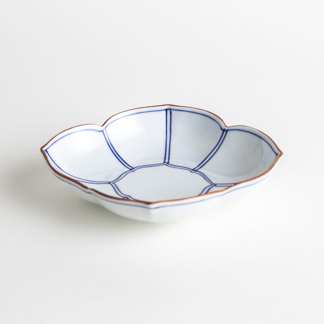 A ceramic bowl shaped like a quince with blue line detailing.