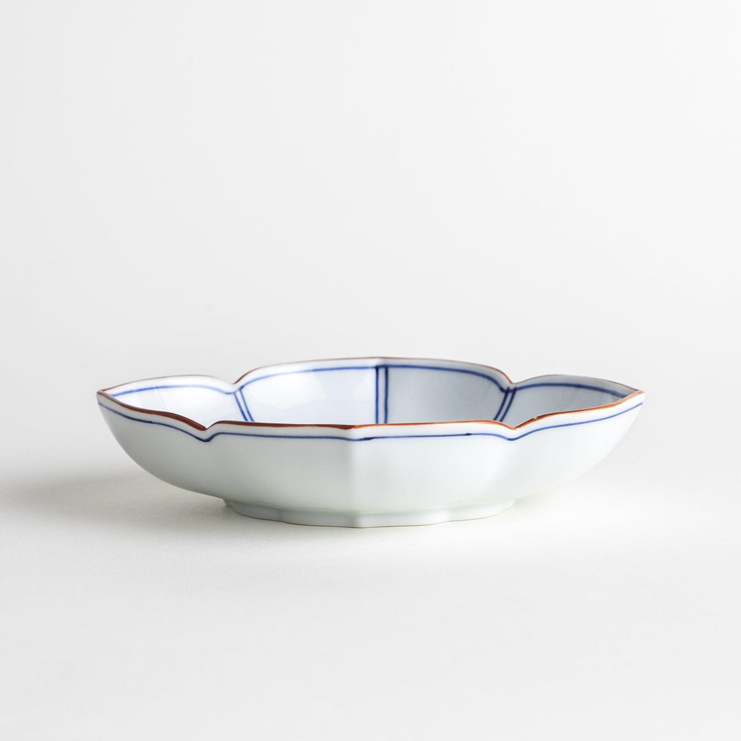 A ceramic bowl shaped like a quince with blue line detailing.
