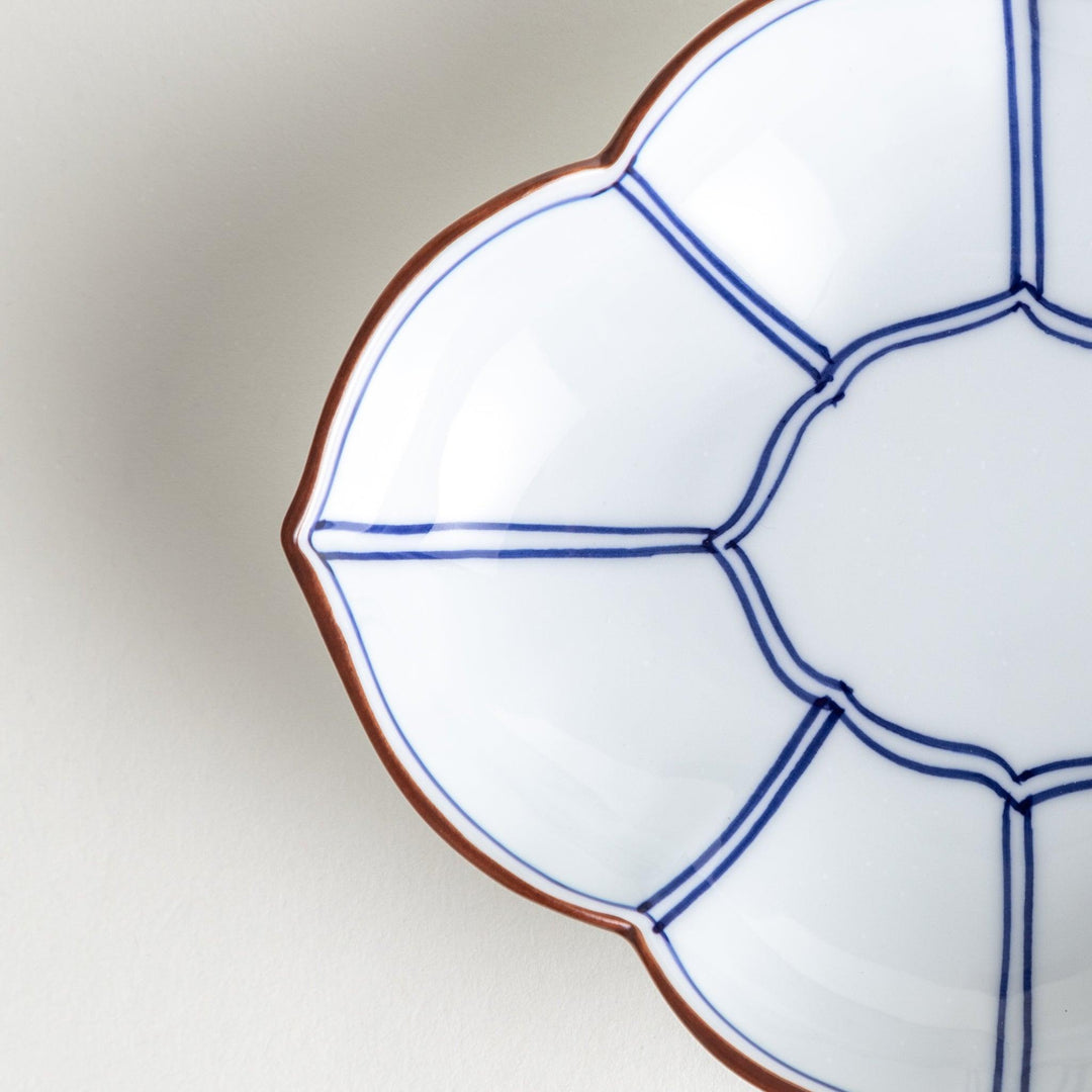 A ceramic bowl shaped like a quince with blue line detailing.