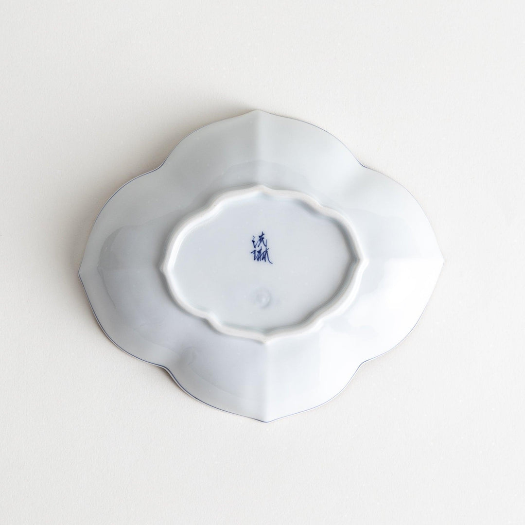 A ceramic bowl shaped like a quince with blue line detailing.