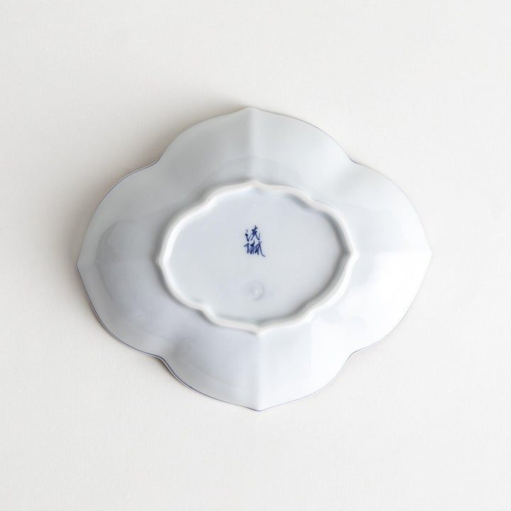 A ceramic bowl shaped like a quince with blue line detailing.