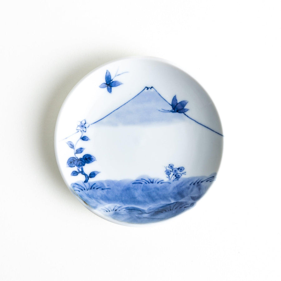 Round plate with a blue and white Mount Fuji and butterfly scene.