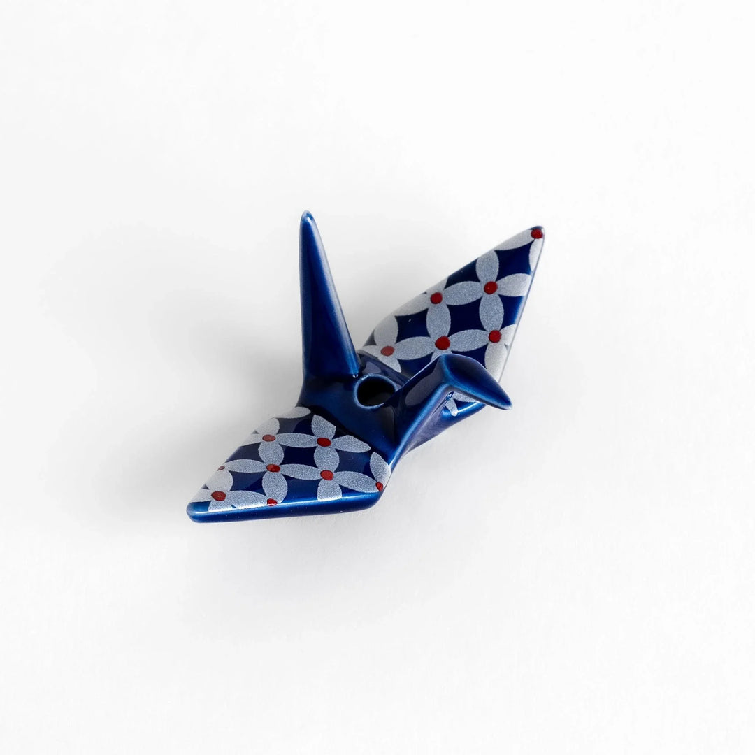 Blue origami crane incense holder with silver and red geometric pattern adding artistic charm to your space.