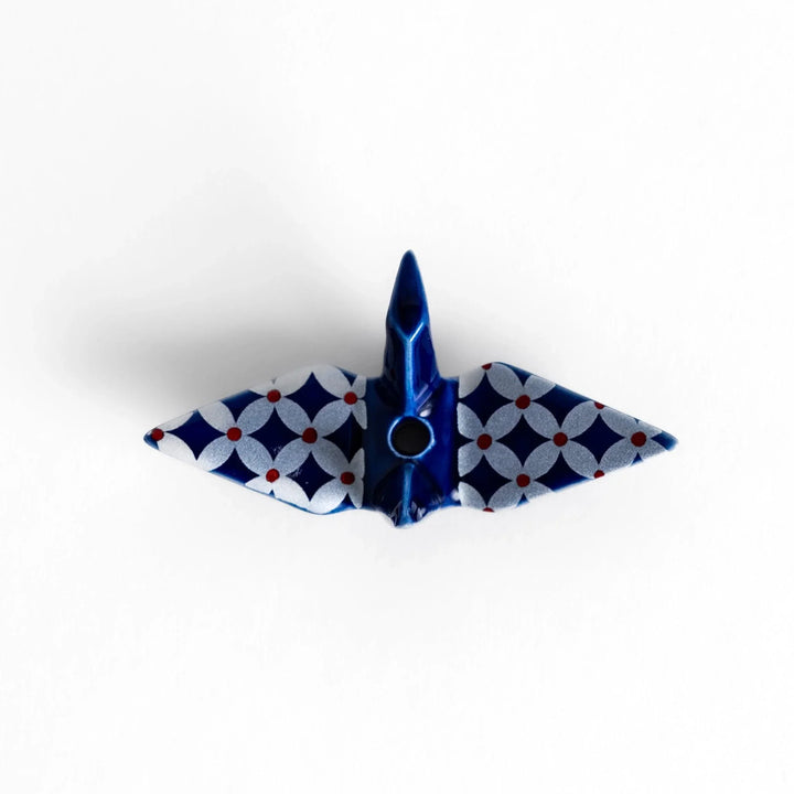 Blue origami crane incense holder with a geometric silver and red pattern, adding a unique, artistic touch to your space.