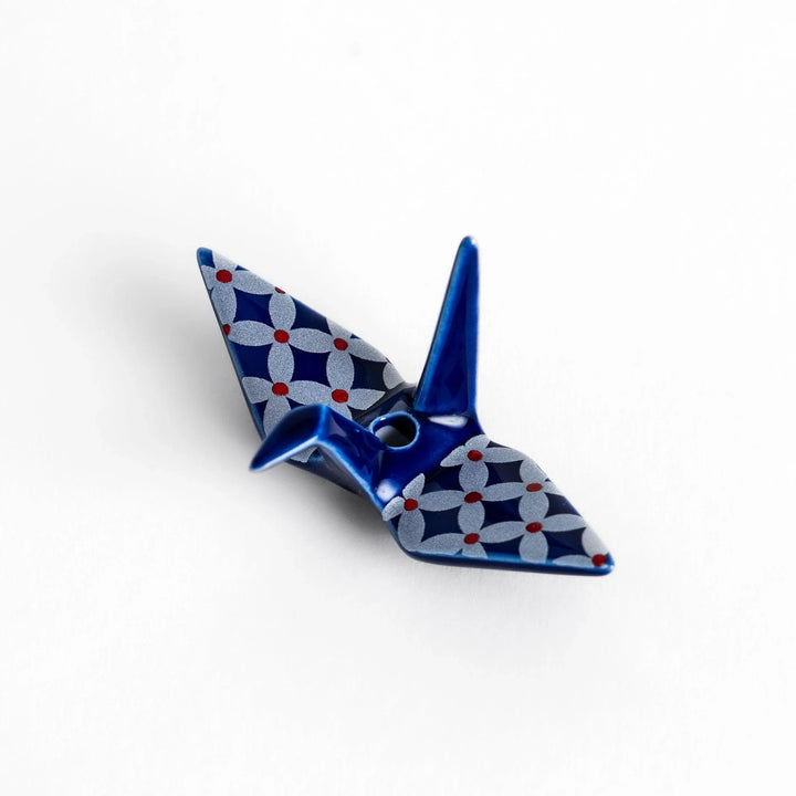 Blue origami crane incense holder with a geometric silver and red pattern, adding a unique, artistic touch to your space.