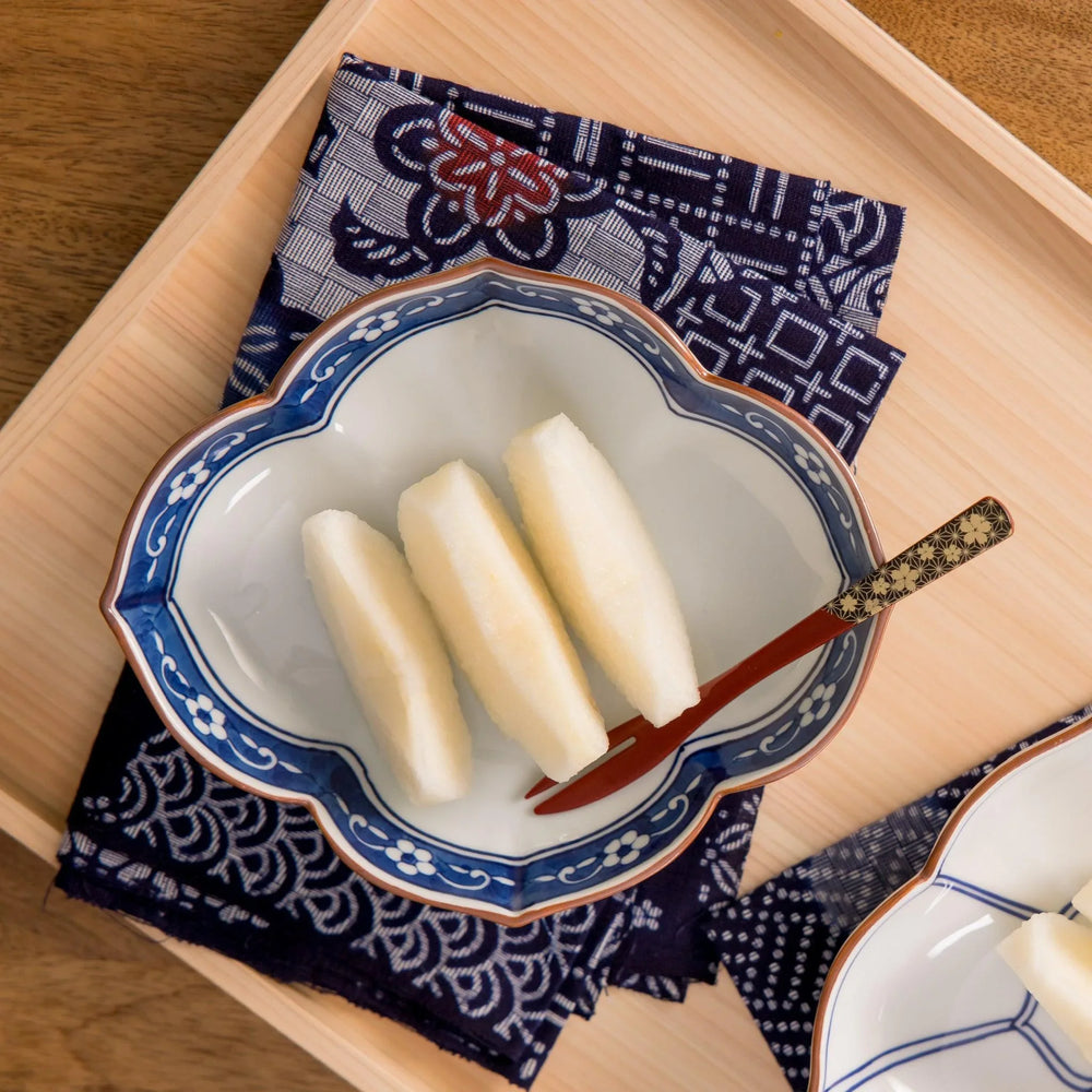 Petite raised Japanese sauce dish with colorful butterflies and floral patterns and striped multicolor base.