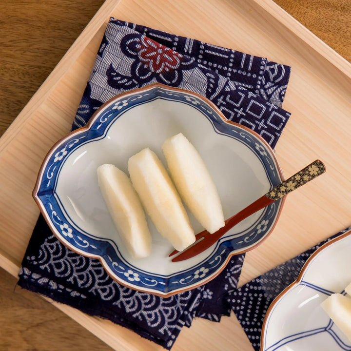Petite raised Japanese sauce dish with colorful butterflies and floral patterns and striped multicolor base.