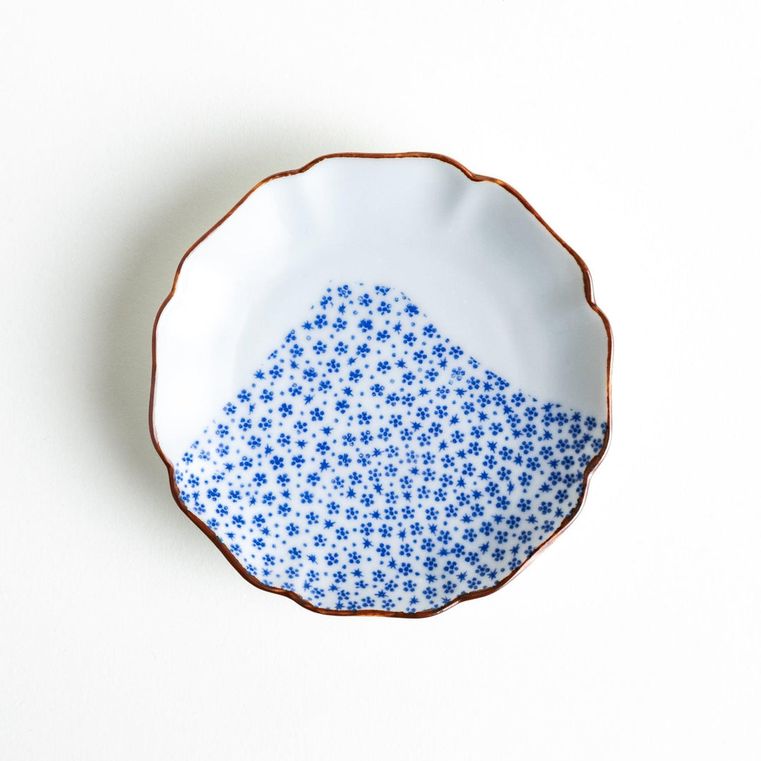 Small Japanese dish with soft blue Mount Fuji pattern and white section forming abstract mountain design.