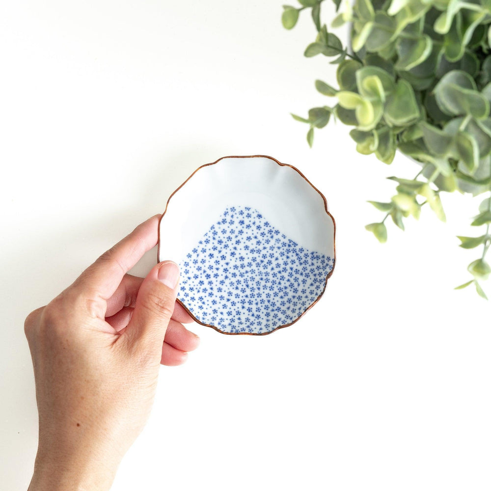 Small Japanese dish with soft blue Mount Fuji pattern and white section forming abstract mountain design.