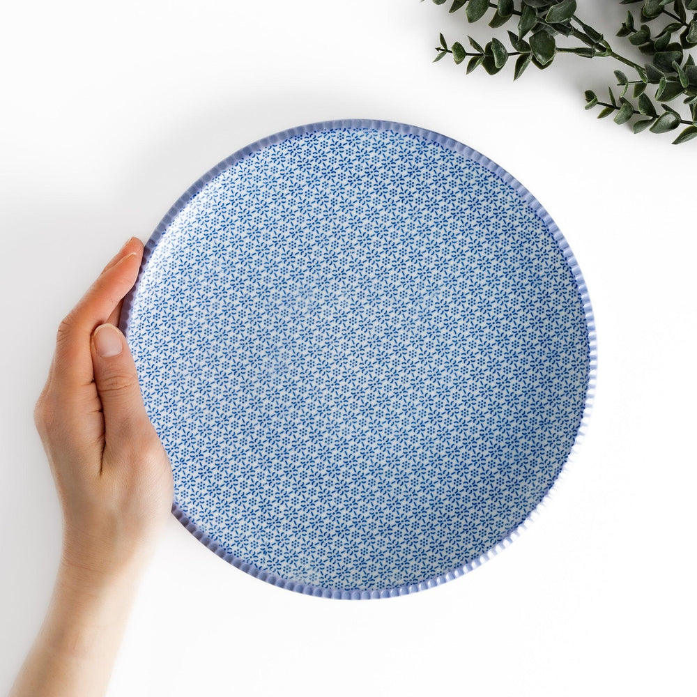 Blue and white floral patterned Japanese dinner plate with subtle striped rim for refined dining style.