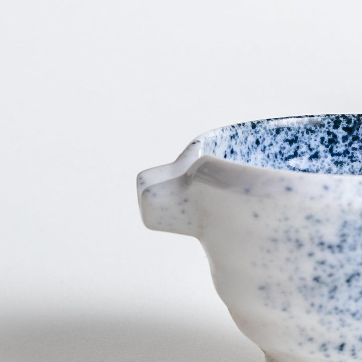 A small condiment bowl with blue speckled patterns on a white background.