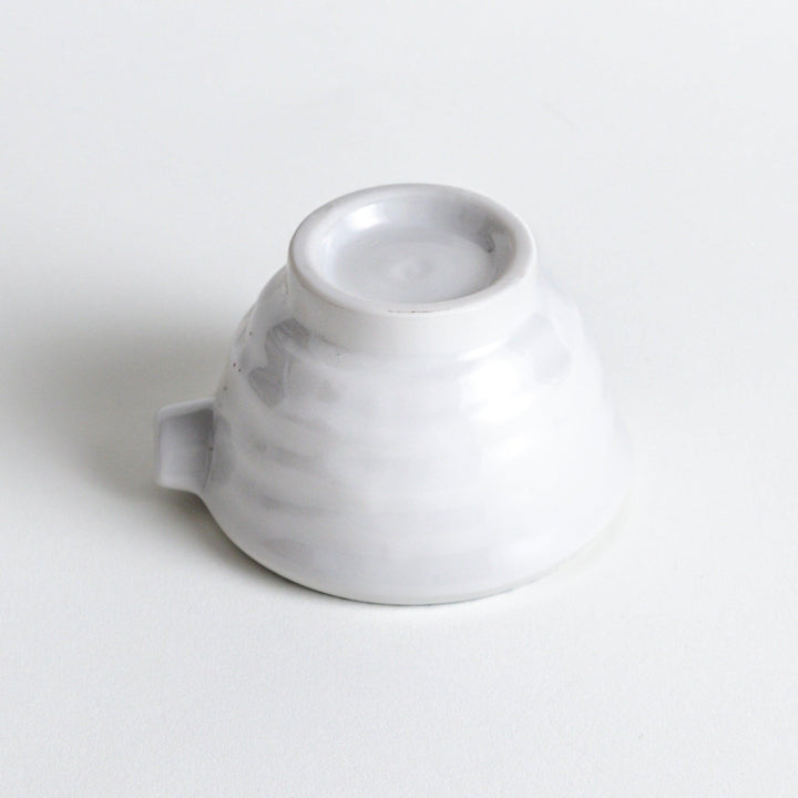 A small condiment bowl with blue speckled patterns on a white background.