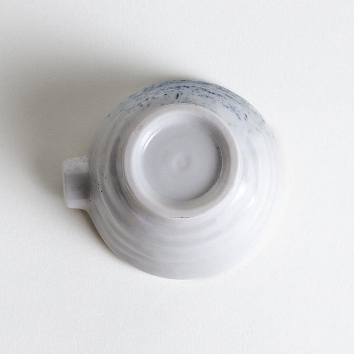 A small condiment bowl with blue speckled patterns on a white background.