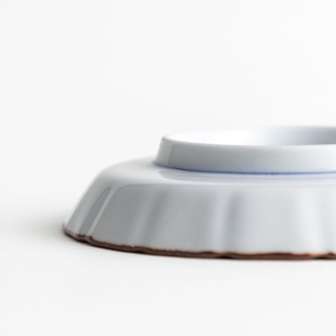 A small round plate featuring a blue swirl design with Mount Fuji background.