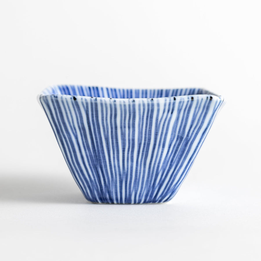 A small, square white plate with a geometric pattern of intersecting blue lines.