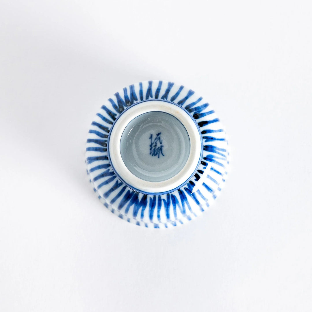 Bottom view of the tea cup showing the small, rounded base and the continuation of the blue stripe design.