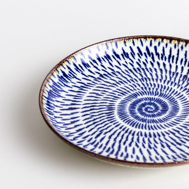 A blue and white salad plate with a concentric spiral pattern/