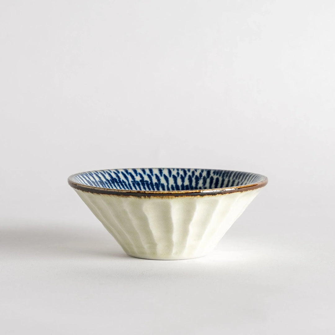 A small, shallow bowl with a flared edge, decorated with blue brushstroke patterns.