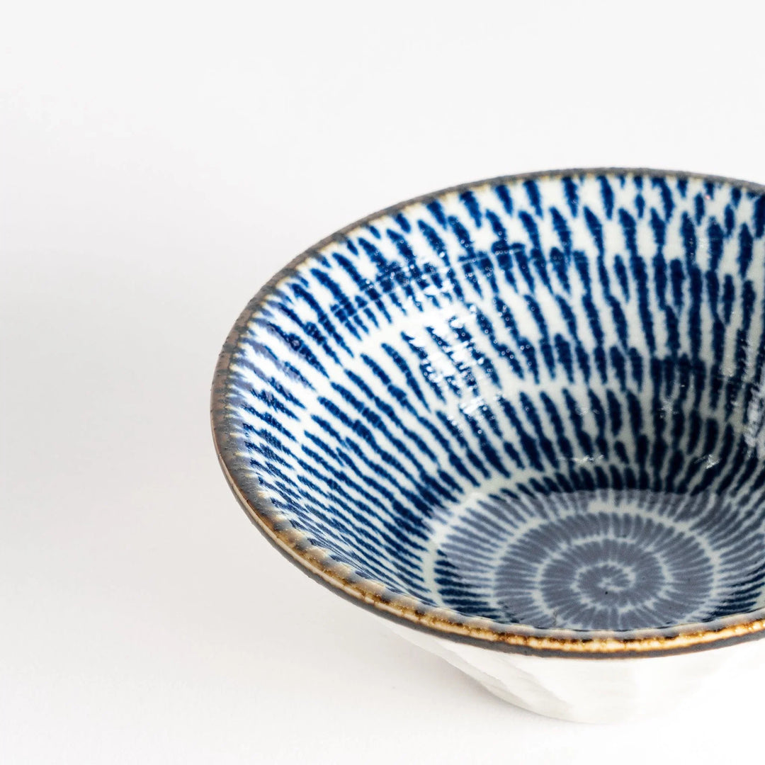 A small, shallow bowl with a flared edge, decorated with blue brushstroke patterns.