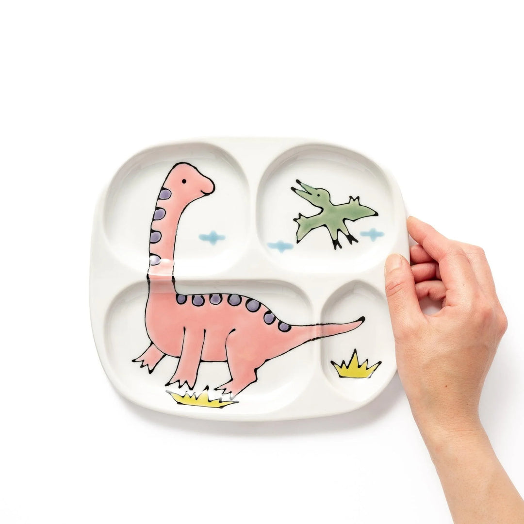Japanese ceramic kids dinnerware set with pink dinosaur and green pterodactyl design including plate bowl and mug.