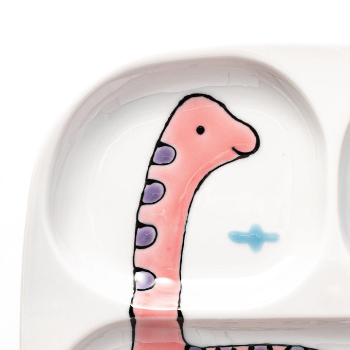 Japanese ceramic kids plate with cute pink dinosaur and green pterodactyl design featuring four divided sections.