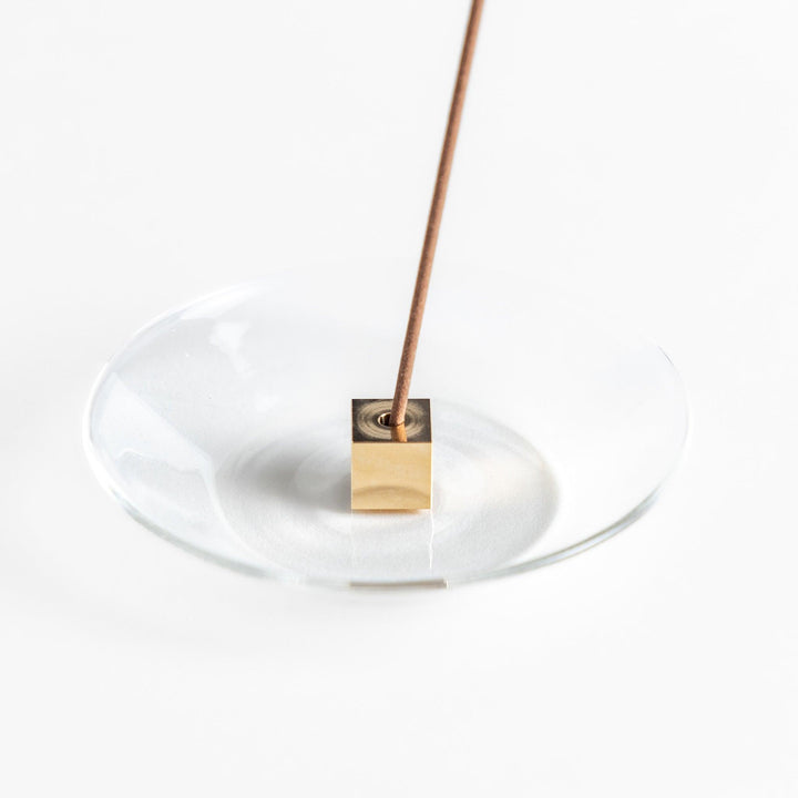 Glass and brass incense holder set combining modern design and function for elegant incense display.