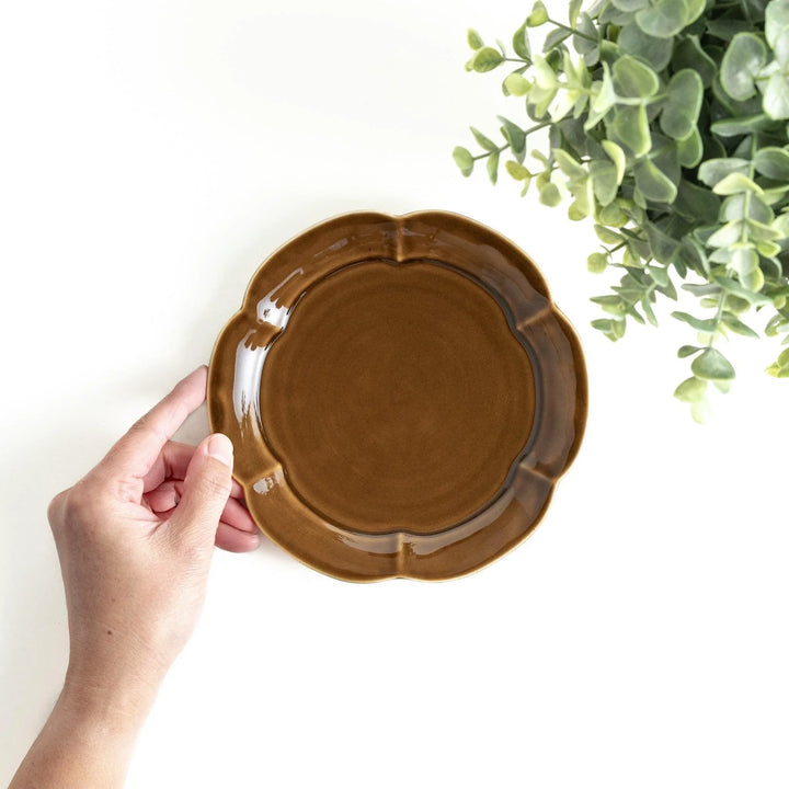 Earthy tones of olive, caramel, or off-white dessert plate, with a soft, rounded shape and subtle color variations.