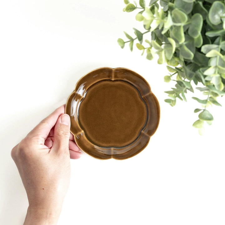 Small flower-shaped sauce dish in green, brown, and white.