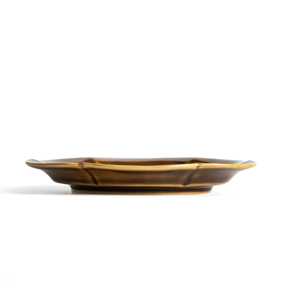 Small flower-shaped sauce dish in green, brown, and white.