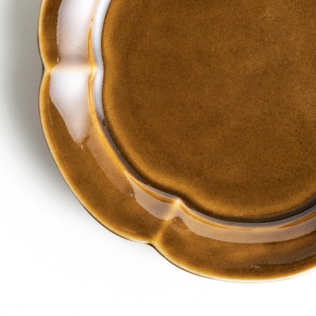 Small flower-shaped sauce dish in green, brown, and white.