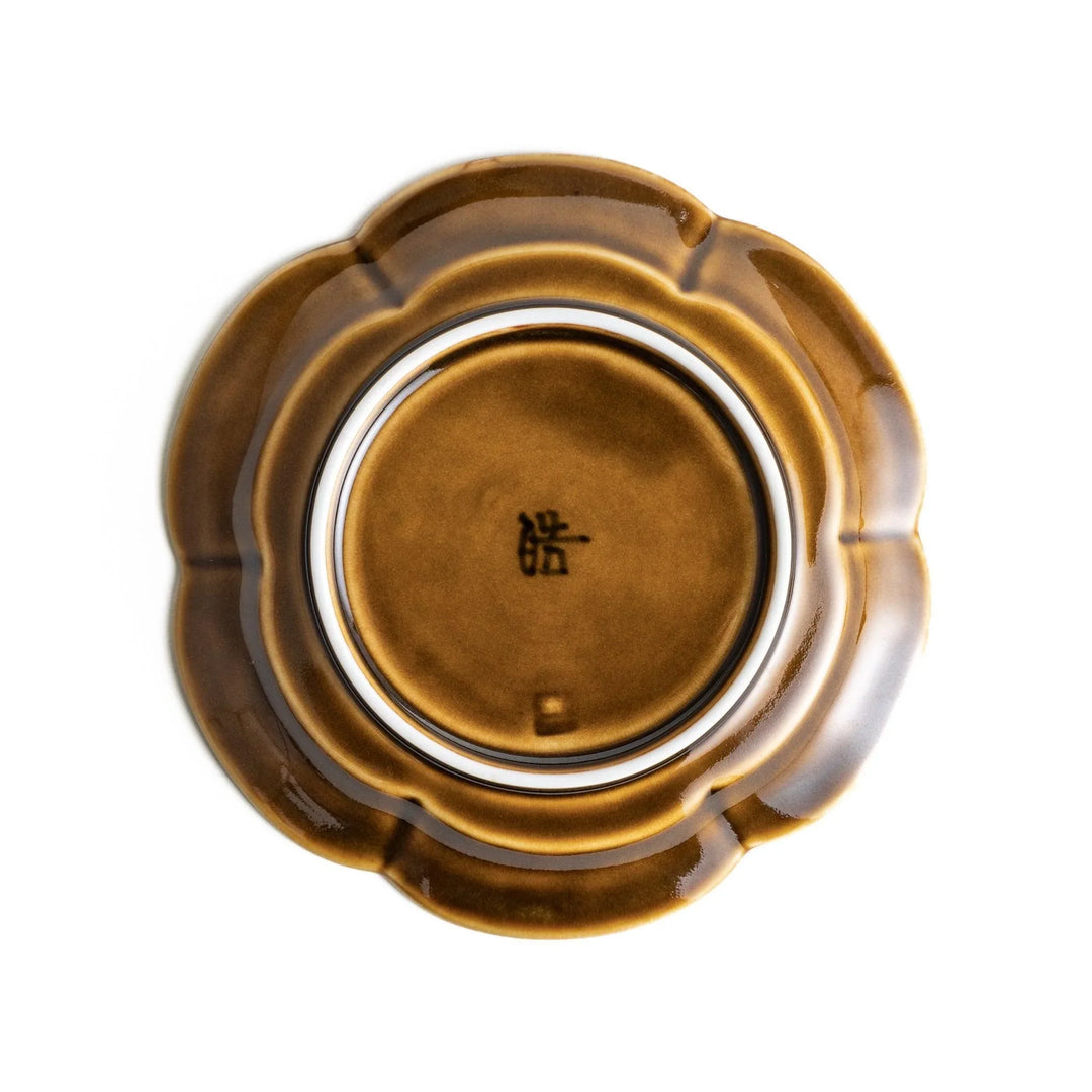 Small flower-shaped sauce dish in green, brown, and white.