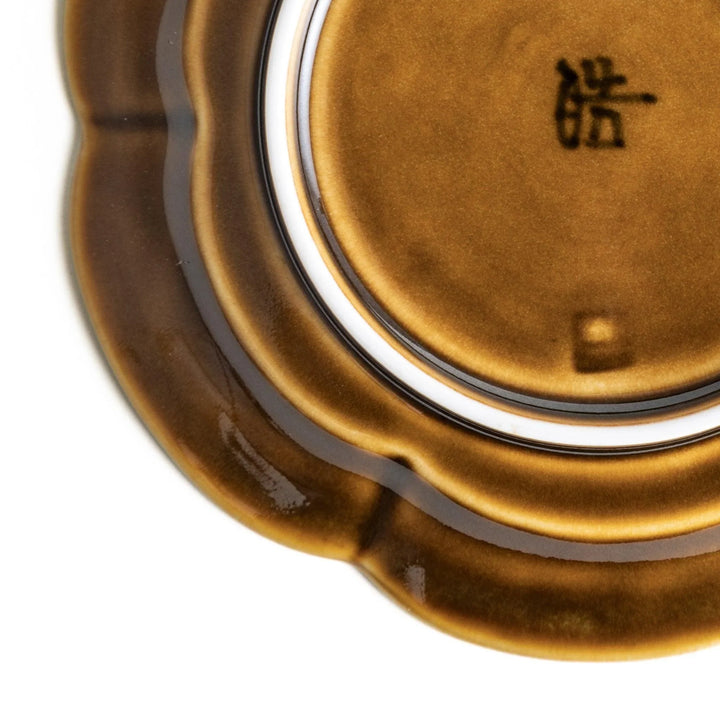 Small flower-shaped sauce dish in green, brown, and white.