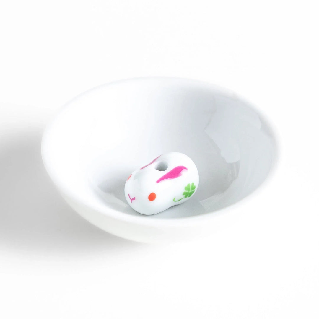 Japanese ceramic bunny incense holder set with small white dish and cute pink and green rabbit charm design.