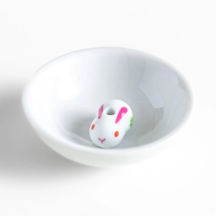 Japanese ceramic bunny incense holder set with small white dish and cute pink and green rabbit charm design.