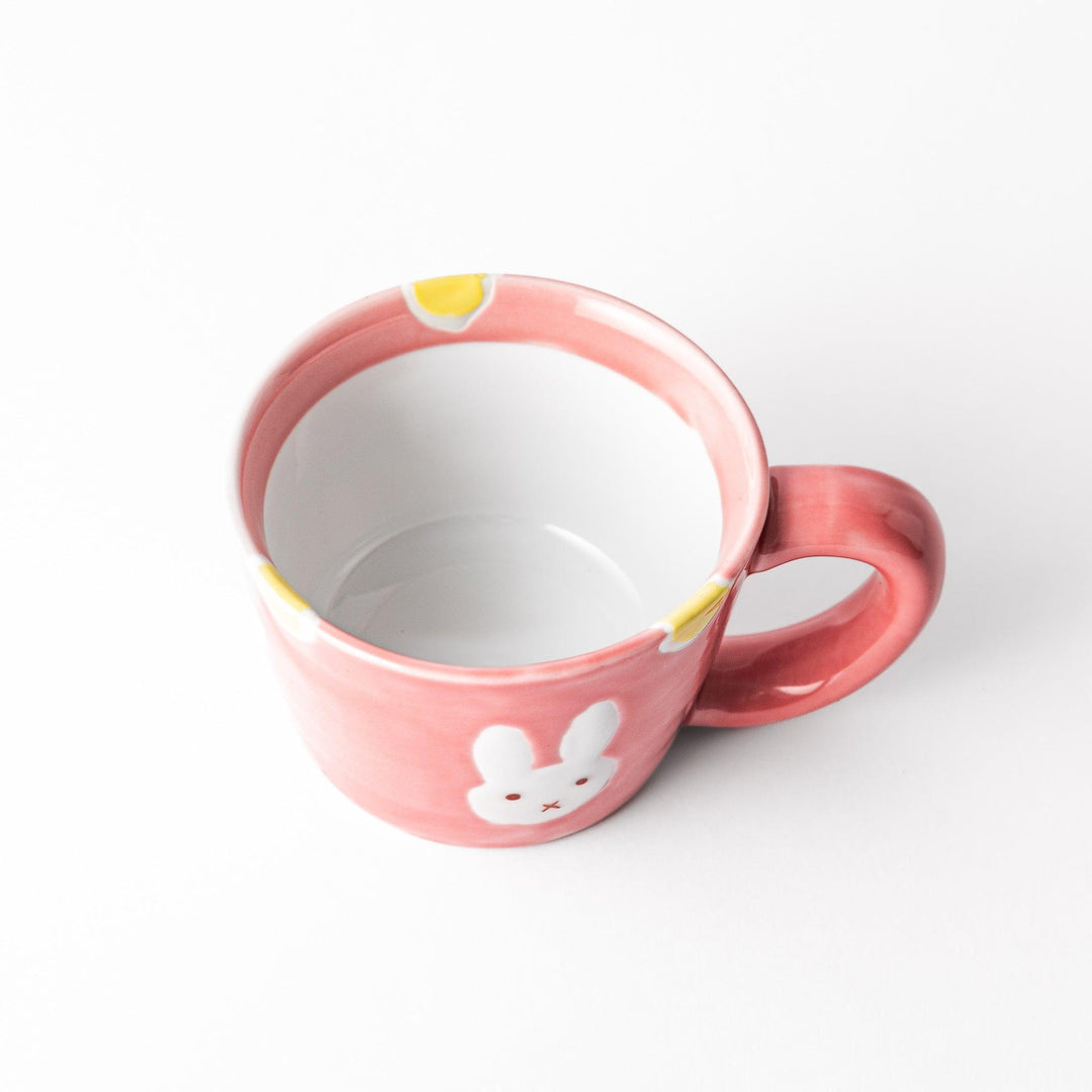 Adorable pink kids' mug featuring a cute bunny design and yellow accents, perfect for young children and adding a fun touch to mealtime.