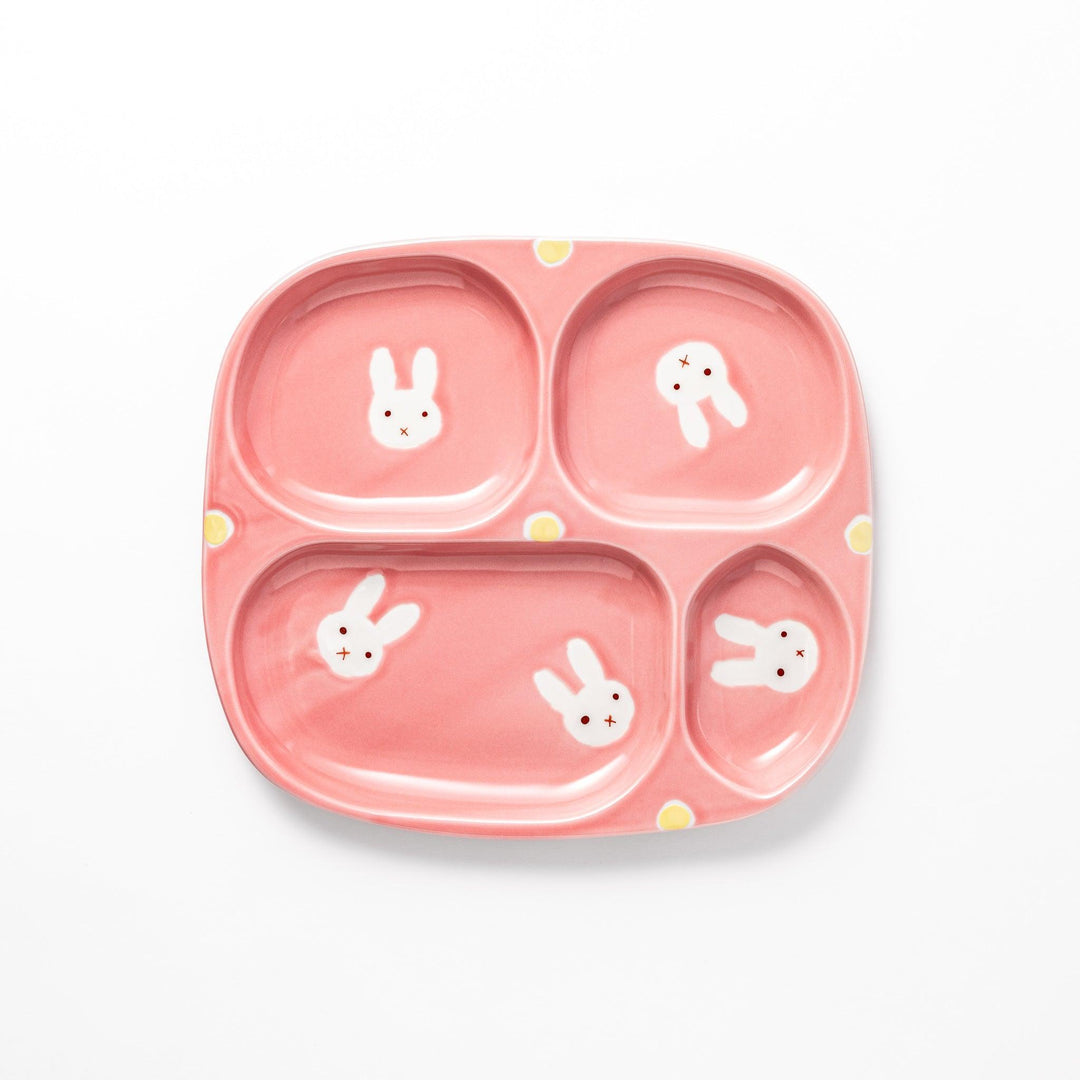 Adorable bunny-themed kids' plate featuring four sections, each with a cute bunny illustration, set in a cheerful pink color with yellow accents.