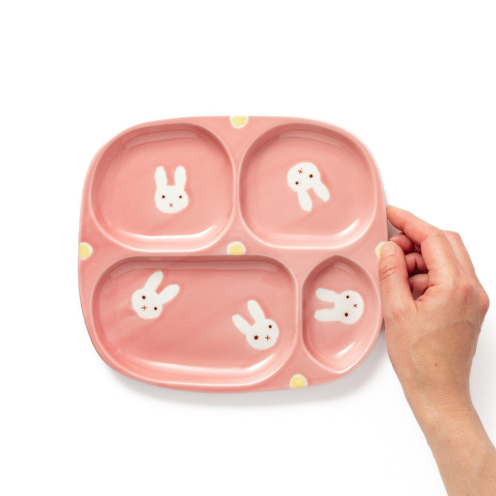 Adorable bunny-themed kids' plate featuring four sections, each with a cute bunny illustration, set in a cheerful pink color with yellow accents.