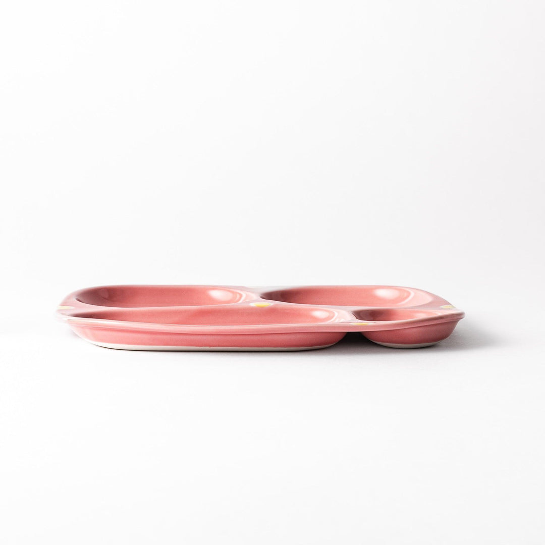 Adorable bunny-themed kids' plate featuring four sections, each with a cute bunny illustration, set in a cheerful pink color with yellow accents.