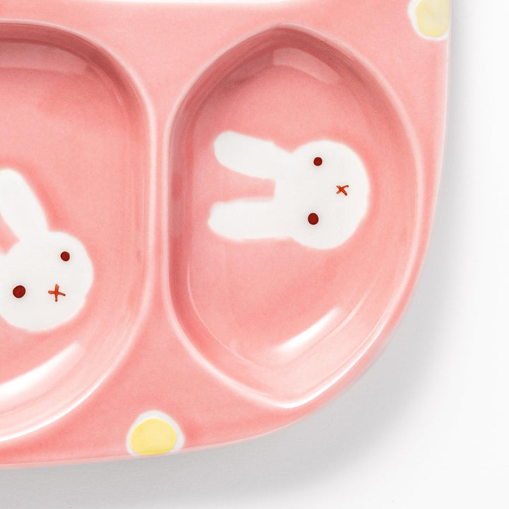 Adorable bunny-themed kids' plate featuring four sections, each with a cute bunny illustration, set in a cheerful pink color with yellow accents.