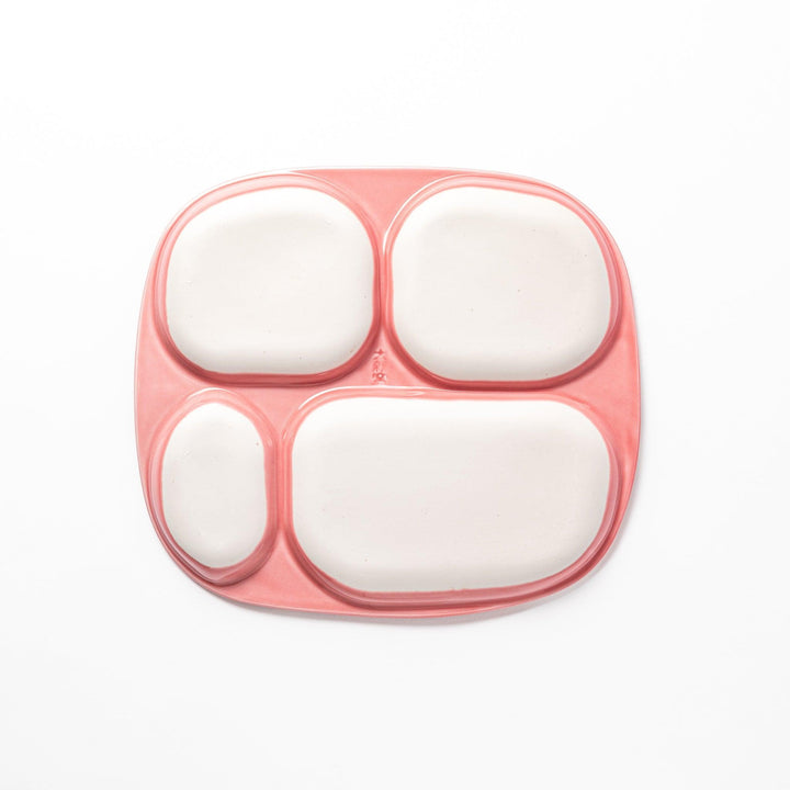 Adorable bunny-themed kids' plate featuring four sections, each with a cute bunny illustration, set in a cheerful pink color with yellow accents.