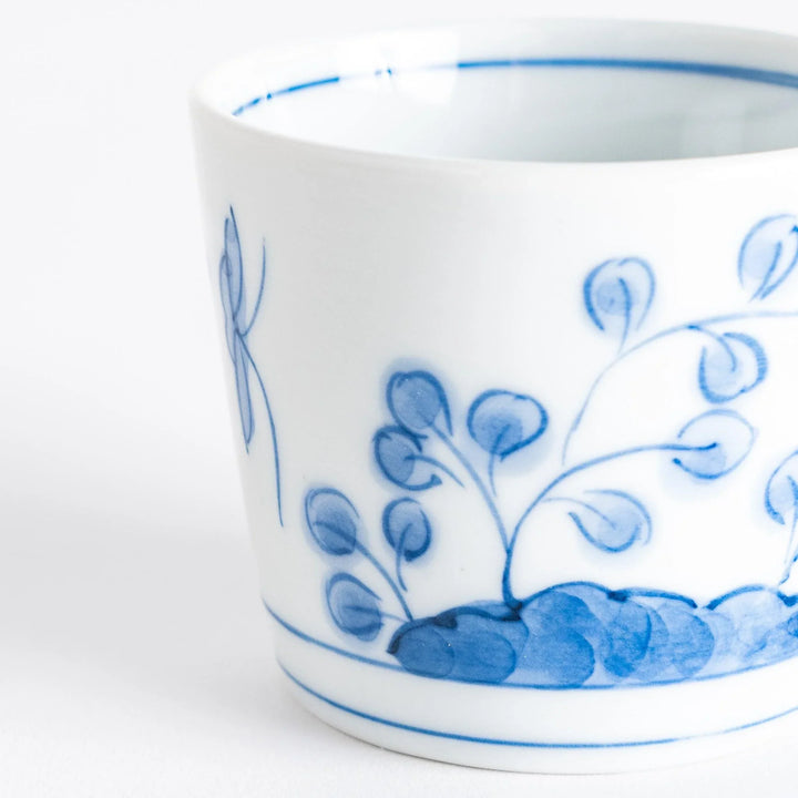 A white condiment bowl decorated with blue bush clover patterns around the side, ideal for small servings or sauces.