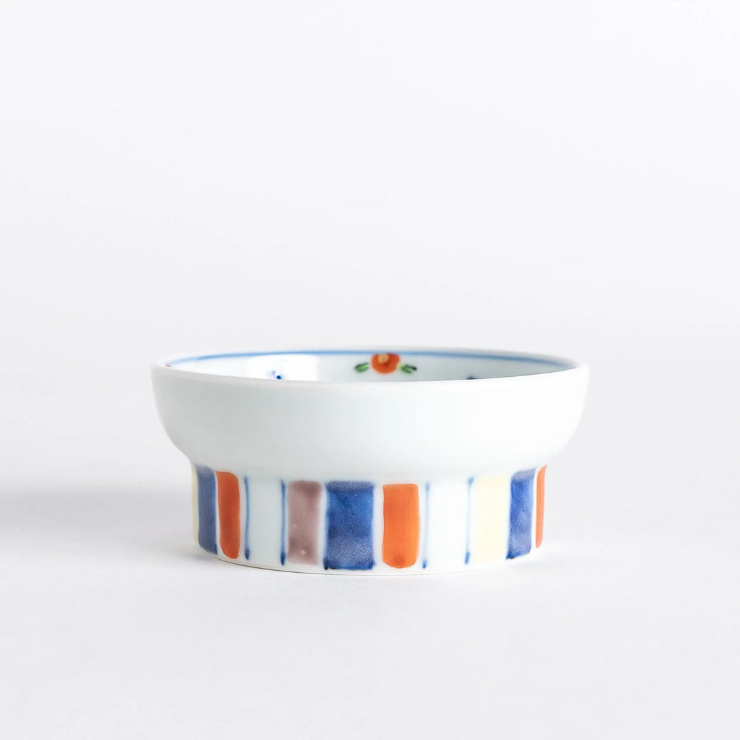 Petite raised Japanese sauce dish with colorful butterflies and floral designs and multicolored striped base.