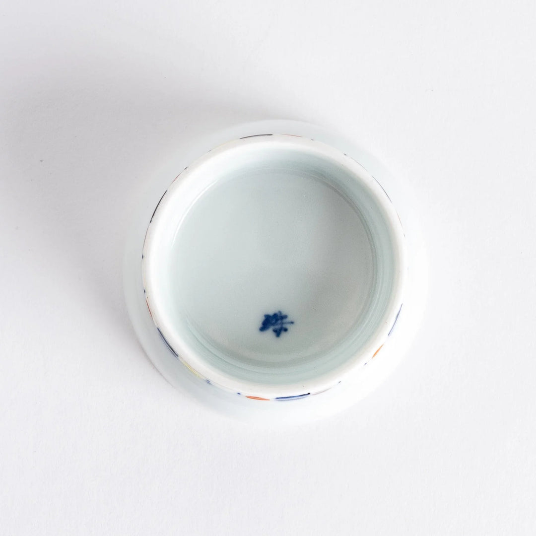 Petite raised Japanese sauce dish with colorful butterflies and floral designs and multicolored striped base.