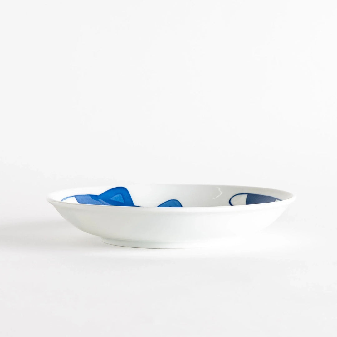 A cereal bowl with a cheerful blue and white cat, playfully kicking its leg up.