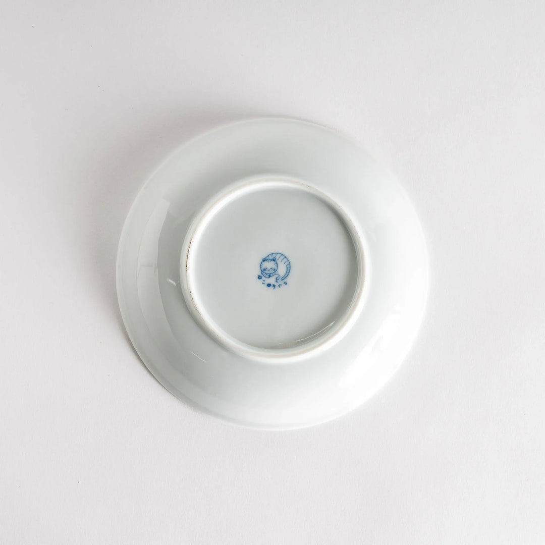 A cereal bowl with a cheerful blue and white cat, playfully kicking its leg up.